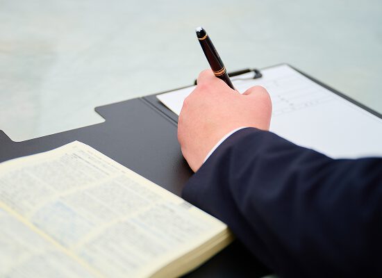 弁護士が相談者の話を記録しているシーン。対応の丁寧さを象徴。