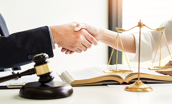 弁護士と依頼者が握手を交わすシーン。信頼関係の構築を象徴。