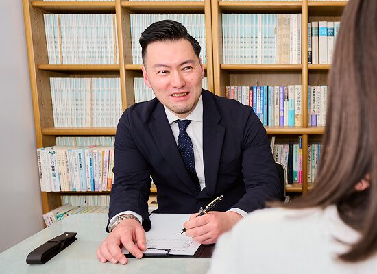 若手弁護士が相談者に丁寧に説明している様子。安心できる相談風景。