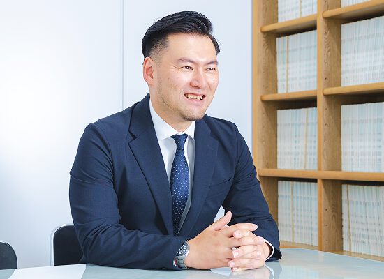 若手弁護士が相談者に向き合い、誠実に話を聞いているシーン。